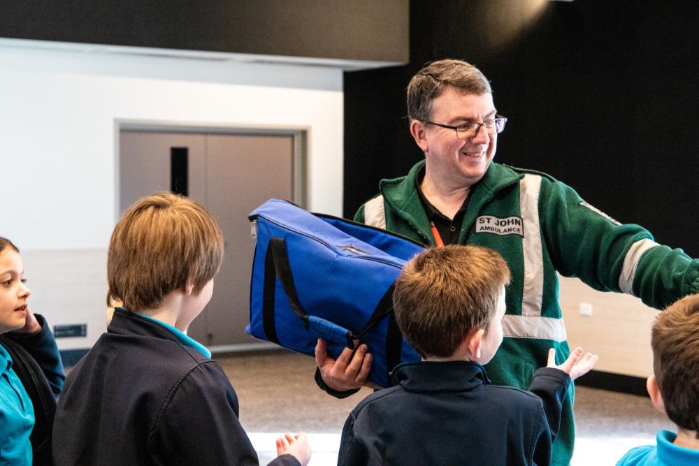 Trainer and school children learning First Aid