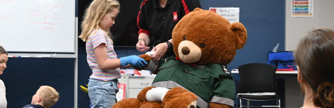 First aid school holiday program child bandaging teddy bear