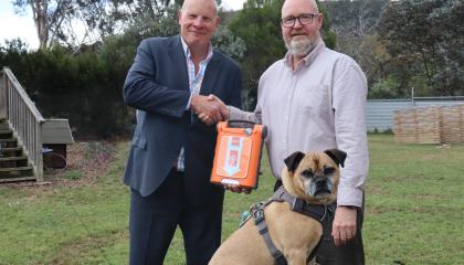 Dogs' Homes Ceo Mark WIld and St John CEO Andrew Paynter with a G5 defib and a dog.
