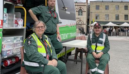 Three St John volunteers sit outside of an ambulance at Salamanca Market