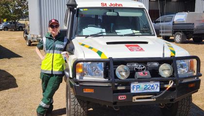 Volunteer in standing by a St John vehicle