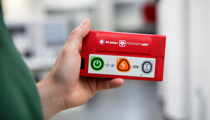Person holding the new St John Pocket AED