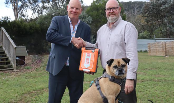 Dogs' Homes Ceo Mark WIld and St John CEO Andrew Paynter with a G5 defib and a dog.
