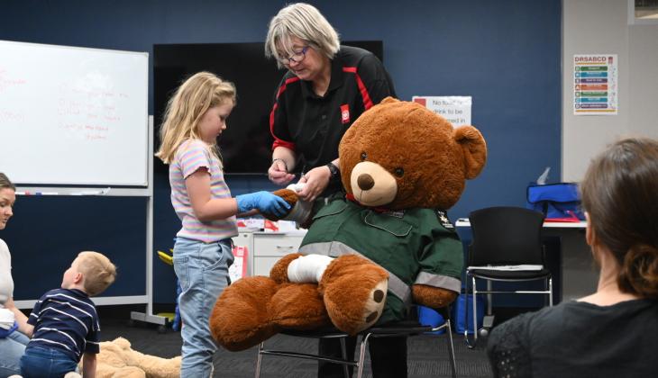 First aid school holiday program child bandaging teddy bear