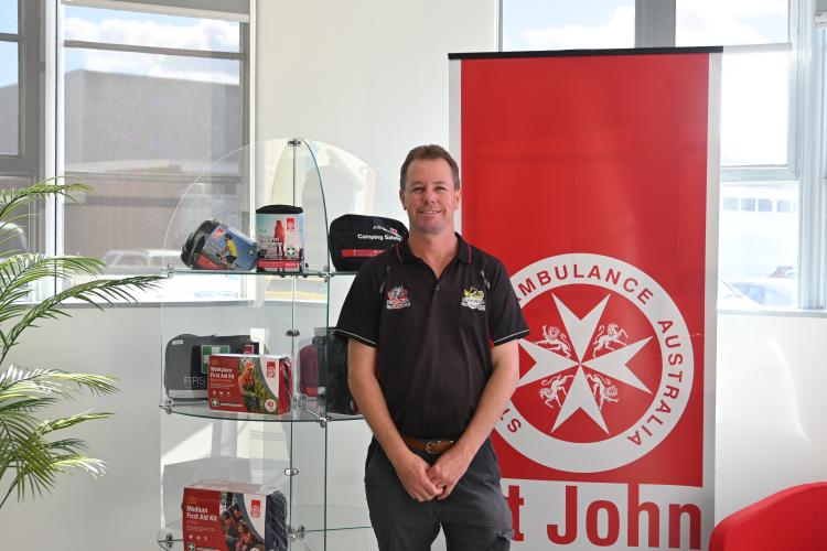 Man standing in front of first aid kits