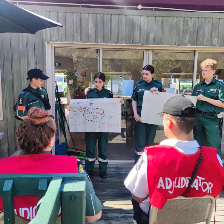 Adult leaders assessing youth program members work at camp