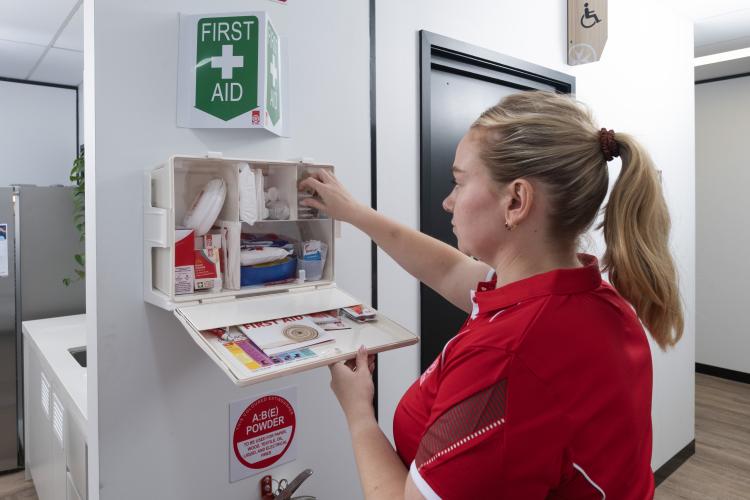 St John staff restocking a wall mounted first aid kit