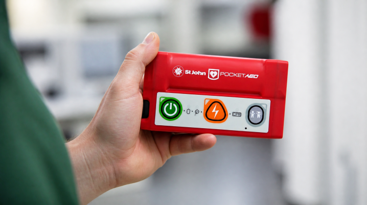 Person holding the new St John Pocket AED